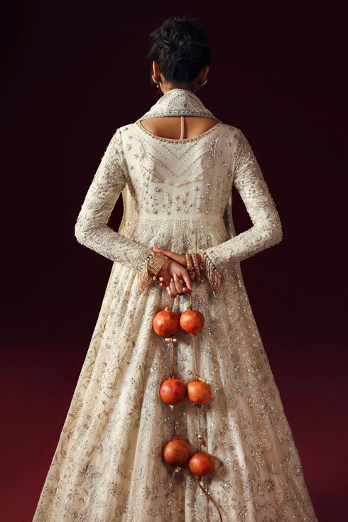 Side view of NAQSHI Nurzaad off‑white gown showing double‑flare panels and sequin embellishments
